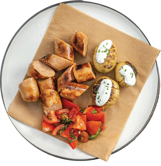 Redefine Bratwurst van de BBQ met gebakken aardappelen en tomatensalade